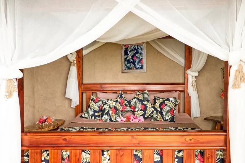A bed with a mosquito net in a room at Paradise Taveuni